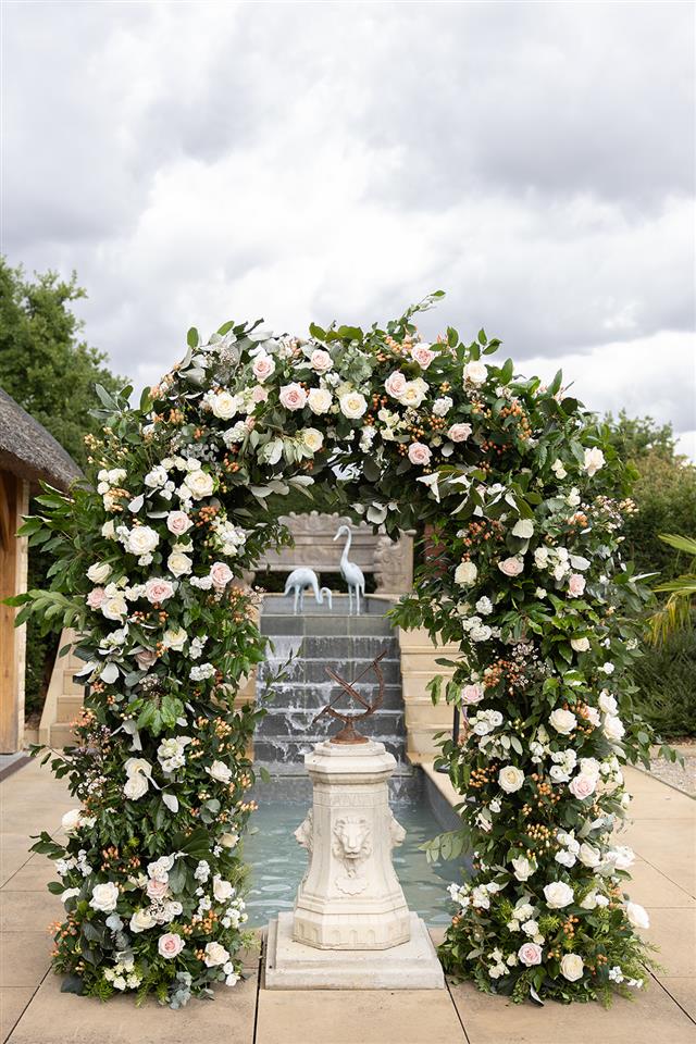 Beautiful ceremony arch of flowers in whites and blush colours by The Flower Mill wedding florist