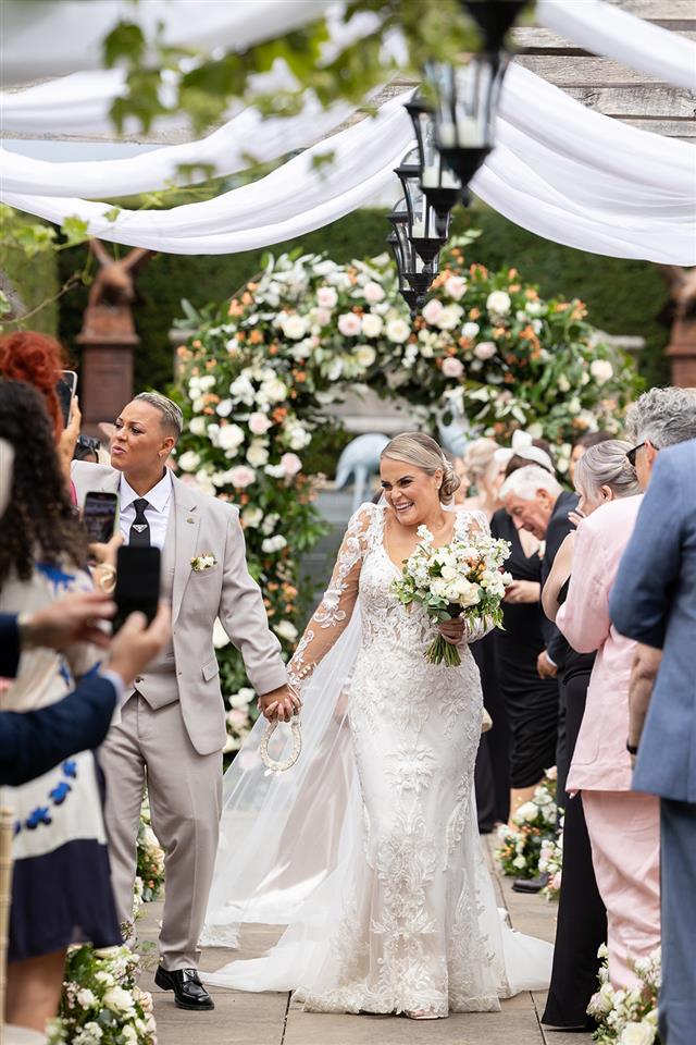 Same sex wedding couple walking down the aisle after the ceremony has finished