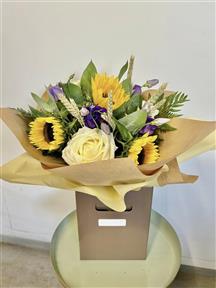 Seasonal Country Sunflower bouquet in water created with a classic selection of cheerful yellow, white and purple flowers. This seasonal fresh flower bouquet includes the best sunflowers, beautiful Roses, country Lisianthus, seasonal dried wheat and complimenting greenery. Each bouquet is created for your order by our florist shop in Thorncote Green in Bedfordshire.