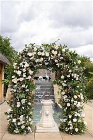 Beautiful ceremony arch of flowers in whites and blush colours by The Flower Mill wedding florist